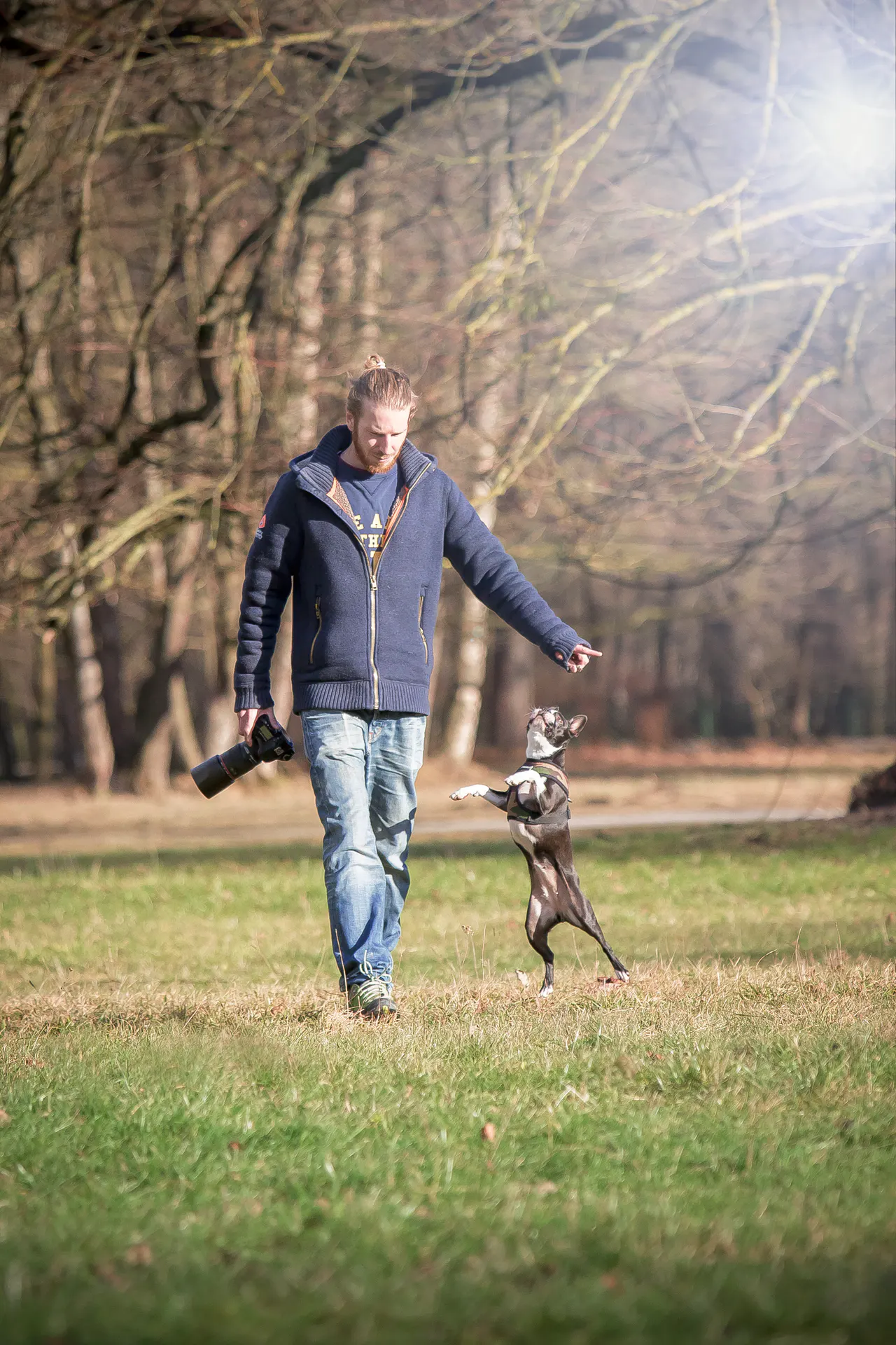 Hansi Trompka mit Hund auf einer Wiese